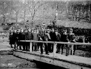 A well-dressed school group early in the 20th century pose on the swing bridge across Wigwell aqueduct at Leawood