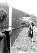 Surveyors from the local authority lining up the critical centre point on which the whole bridge depends. They made regular visits to the site to monitor construction. In the background is the old fixed bridge, raised on sleepers to permit the passage of our small workboat.