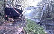 The Smith 14 excavator enroute to High Peak. The bed was too soft to drive on at this point, so we used the towpath instead. This unfortunately reduced the reach of the bucket. (ADS)