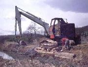 The excavator working mmediately west of Bridge 2. The steep bank at this point required many sleepers to keep the machine upright. There was considerable mud to be removed, caused by outflows of slurry from the Pisani marble works into the canal. (ADS)