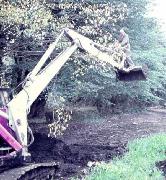 Tree trimming just outside Cromford Wharf. c.1973 with Desmond Stoker standing on the bucket. Note the thickness of dried mud just outside the winding hole!