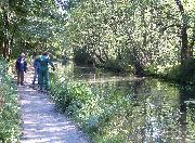 Chatting to a passer-by whilst hauling reeds out of the canal