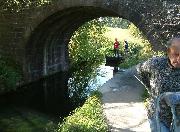 A man-drawn boat, passing under the bridge.