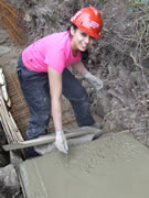 Simran finishes the concreting in the traditional way - by signing her name it - soon to be joined by the others who worked on it... 