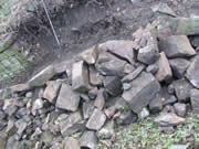 A new stone pile grows from the dismantled section