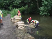 Sunday 5th August - work starts by building the sandbag dam. Photo: George Rogers